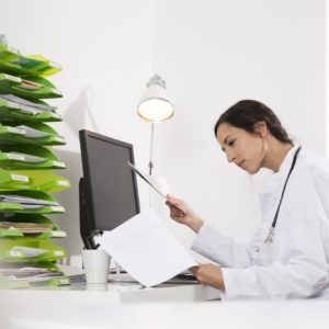 Doctor sitting at desk looking at document